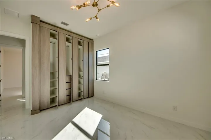 Unfurnished bedroom with a closet and a notable chandelier