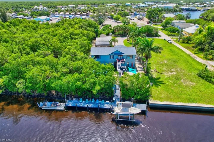 Waterfront property featuring a private boat dock, a separate boat lift, and a multi-level structure with multiple balconies
