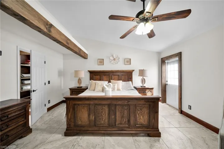 Bedroom with ceiling fan, vaulted ceiling, and light tile patterned floors