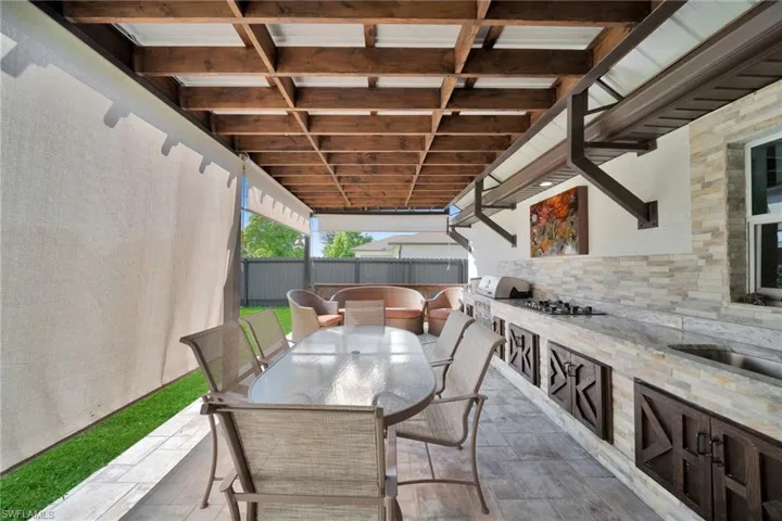 View of patio featuring outdoor dining area and an outdoor kitchen