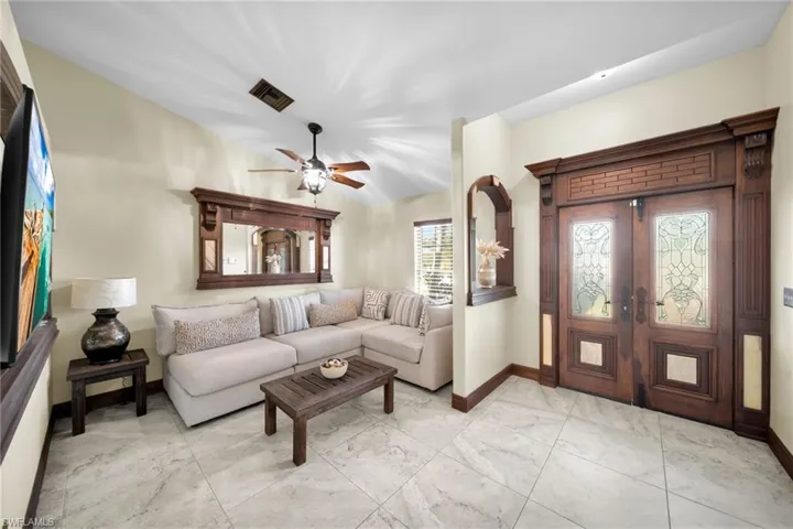 Living room featuring a ceiling fan and french doors