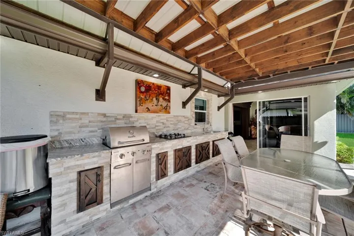 View of patio with outdoor dining area and exterior kitchen
