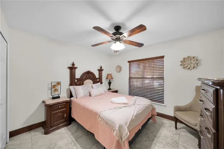 Bedroom with ceiling fan, a closet, and light tile patterned floors