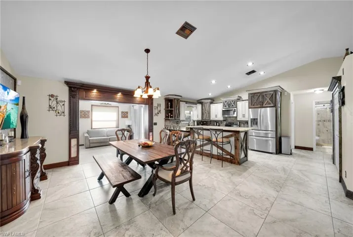 Dining space featuring lofted ceiling, a chandelier, and recessed lighting