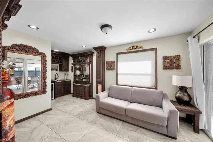Living area with wet bar, recessed lighting, and beverage cooler