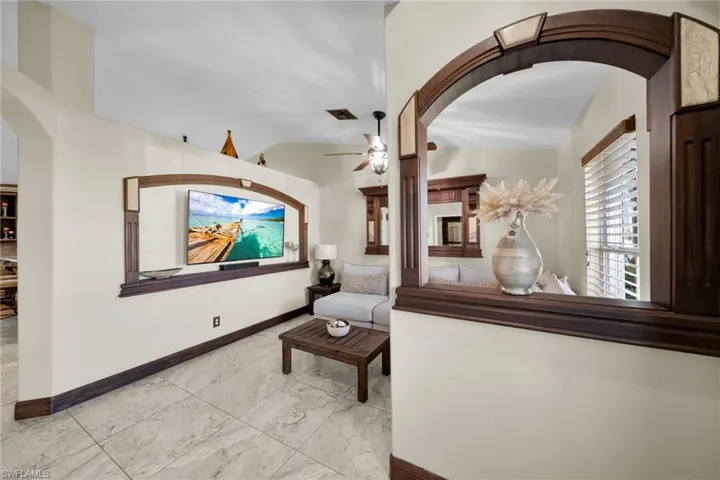 Sitting room with arched walkways and baseboards