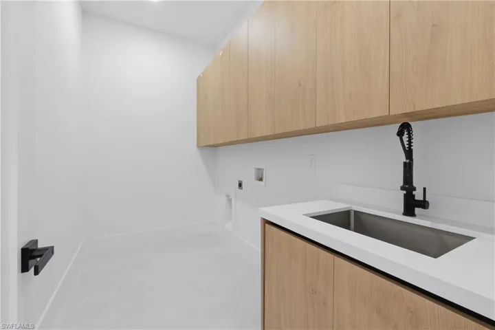 Laundry room with hookup for a washing machine, cabinet space, and hookup for an electric dryer
