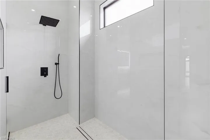 Bathroom with a marble finish shower