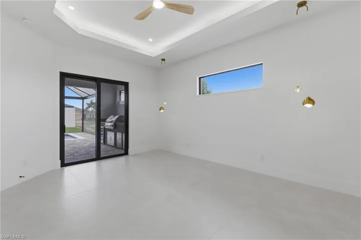 Unfurnished room featuring a ceiling fan and a raised ceiling