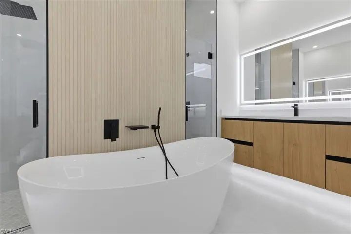 Bathroom featuring vanity, a shower stall, recessed lighting, and a freestanding bath