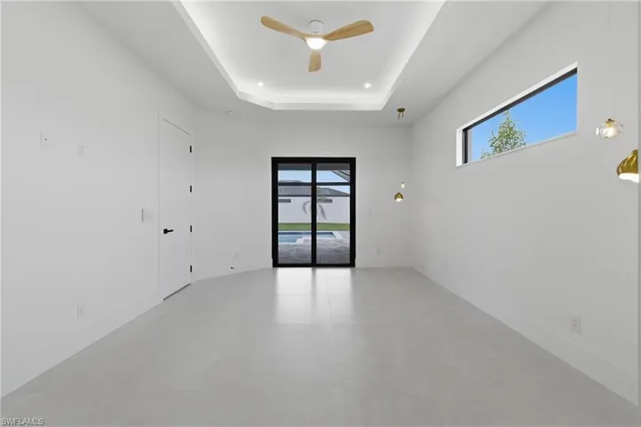 Empty room featuring ceiling fan, a raised ceiling, recessed lighting, and concrete flooring