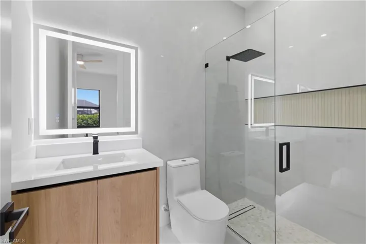 Full bath with a marble finish shower and vanity