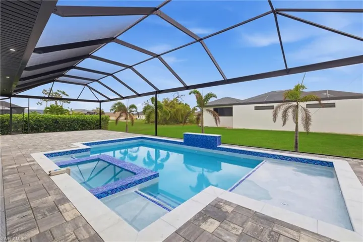 Integrated pool / hot tub with a sunroom, a lawn, and glass enclosure