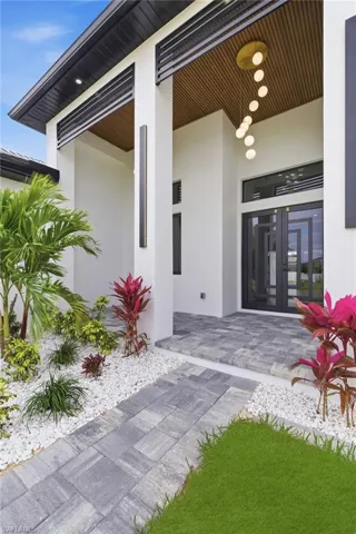 View of exterior entry with stucco siding and french doors