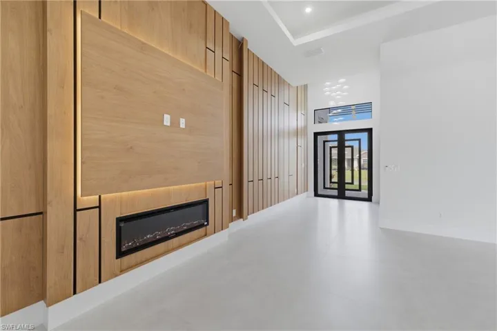 Hallway featuring a high ceiling, recessed lighting, and concrete floors