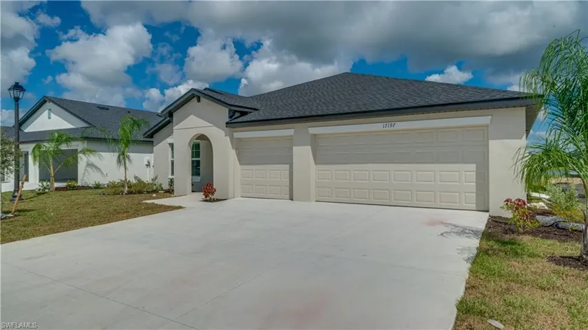 View of front facade featuring roof with shingles, an attached garage, driveway, and stucco siding