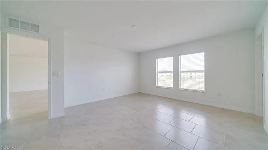 Spare room featuring baseboards and light tile patterned floors