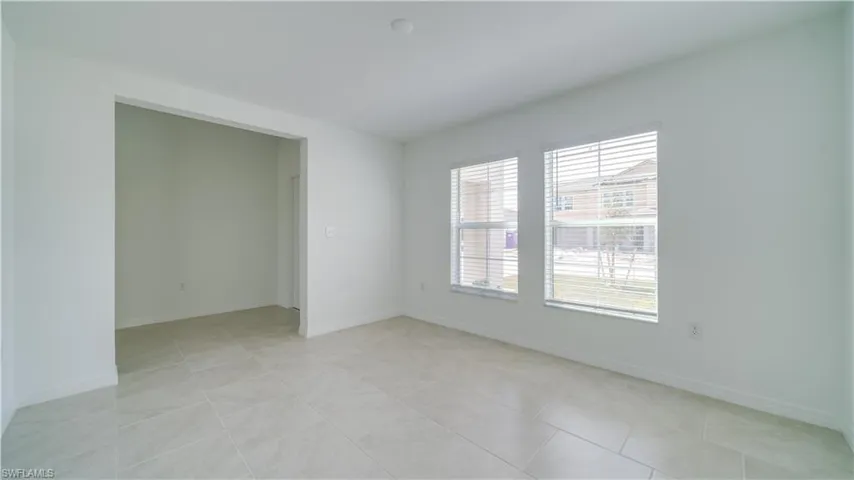 Empty room with baseboards and light tile patterned floors