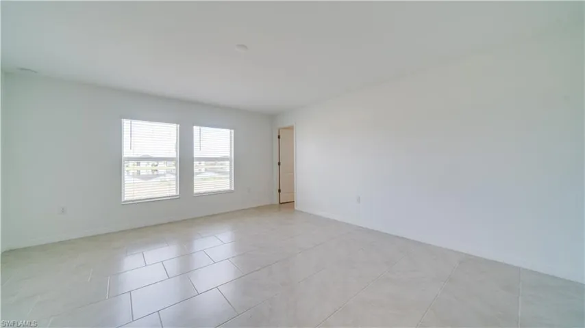 Empty room with baseboards and light tile patterned floors