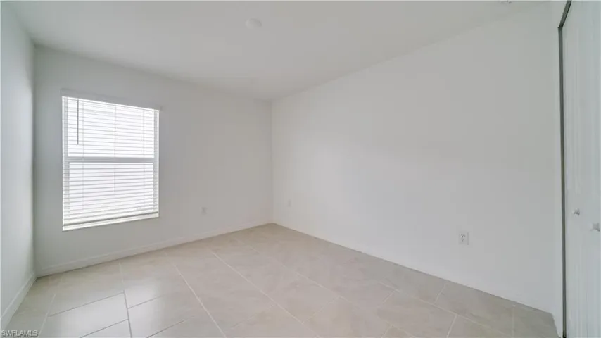 Unfurnished room featuring baseboards and light tile patterned floors