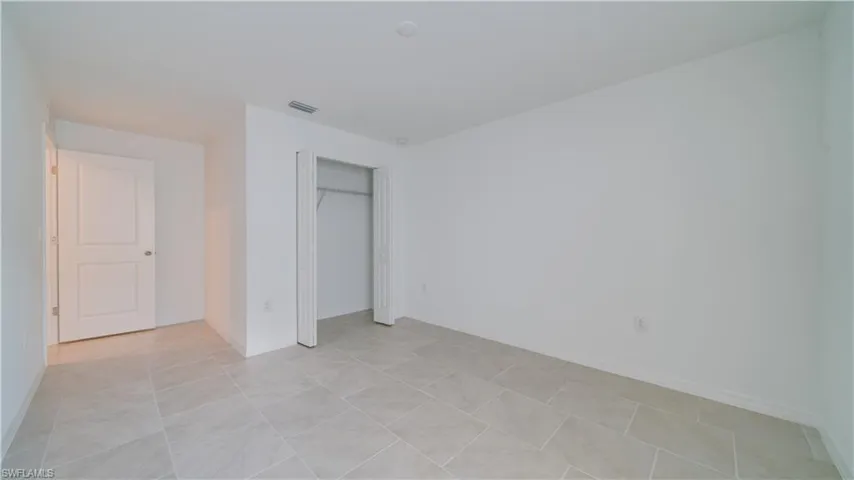 Unfurnished bedroom featuring a closet and light tile patterned floors