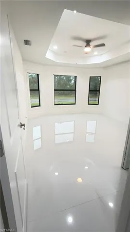 Bathroom featuring recessed lighting, a raised ceiling, and a ceiling fan
