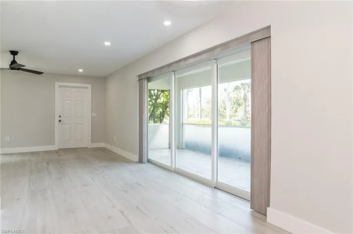 Kitchen with white cabinets, stainless steel appliances, light stone counters, and backsplash