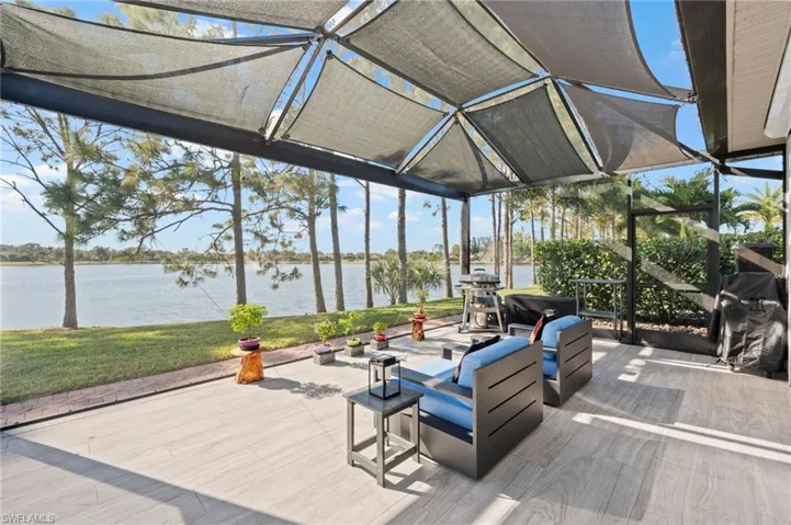 Wooden deck with a water view, a yard, and a sunroom