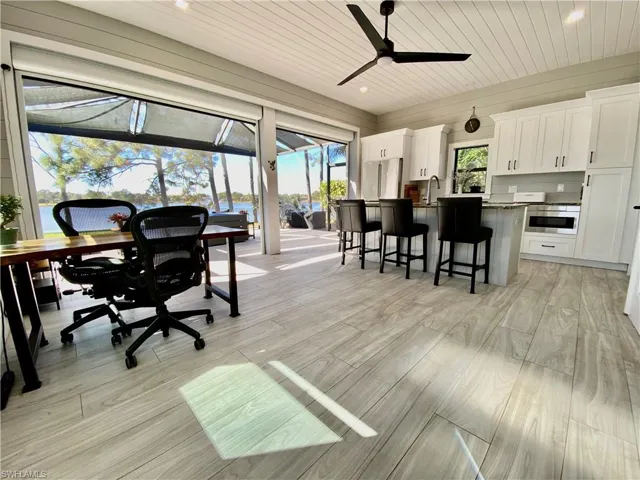 Home office with a sunroom, ceiling fan, light wood finished floors, wooden ceiling, and recessed lighting