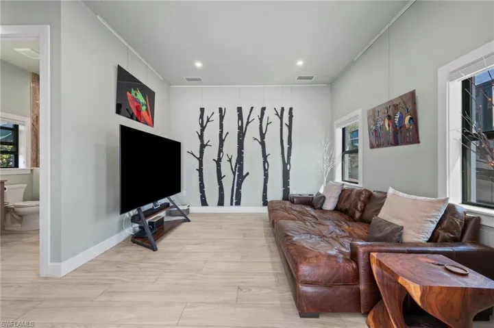 Living room with healthy amount of natural light, light wood-type flooring, and recessed lighting