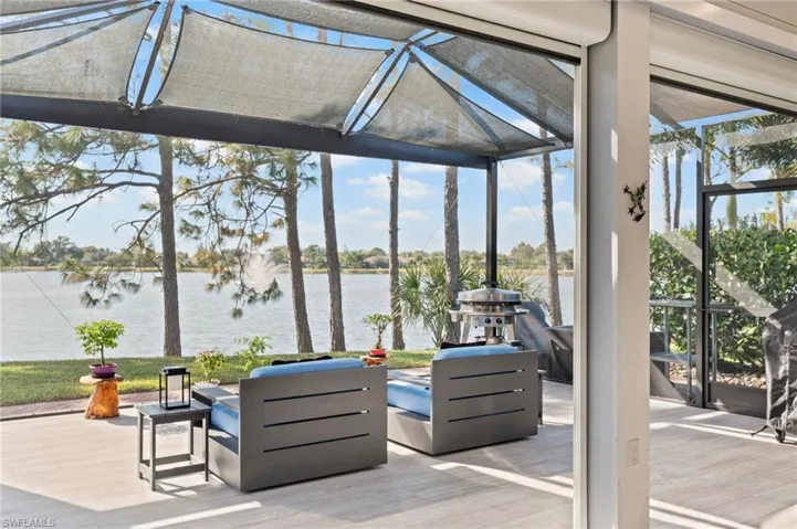 View of patio featuring a water view, a lanai, and a sunroom