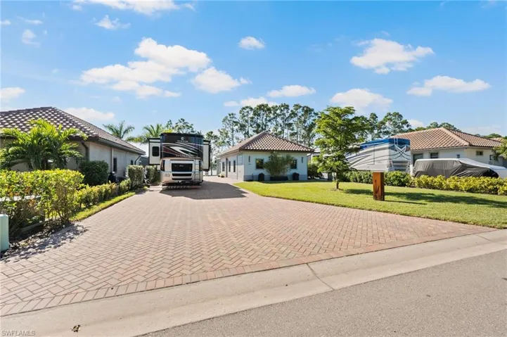 Mediterranean / spanish home with decorative driveway and a front yard