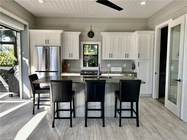 Kitchen with white cabinetry, a center island with sink, plenty of natural light, wood ceiling, and recessed lighting