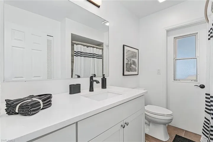 Bathroom featuring tile flooring, vanity with extensive cabinet space, and toilet
