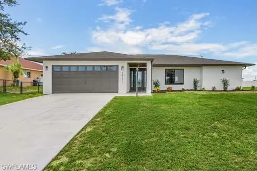 View of front facade with a front yard and a garage