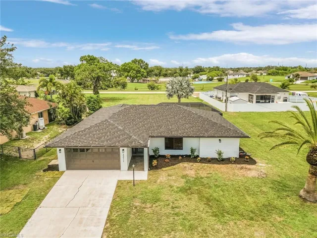 Ranch-style home featuring a garage and a front lawn