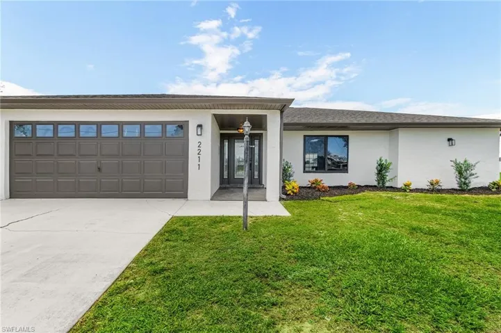 Ranch-style home with a front yard and a garage