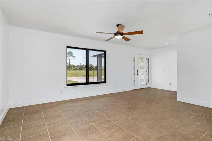 Tiled empty room featuring ceiling fan
