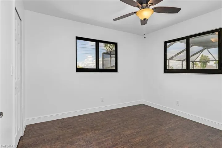 Unfurnished room with ceiling fan and dark hardwood / wood-style flooring