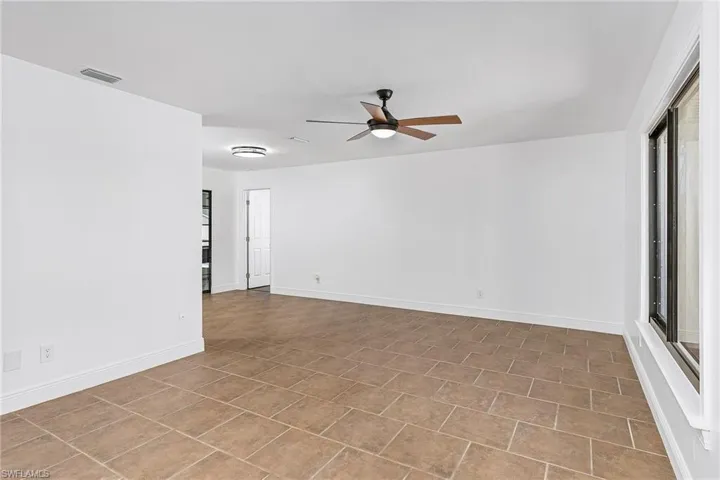Tiled empty room with ceiling fan