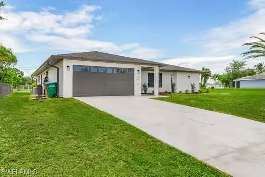 View of front of house featuring a garage and a front yard