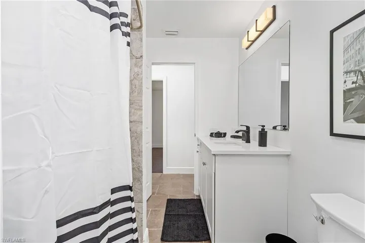 Bathroom featuring tile floors, toilet, and vanity