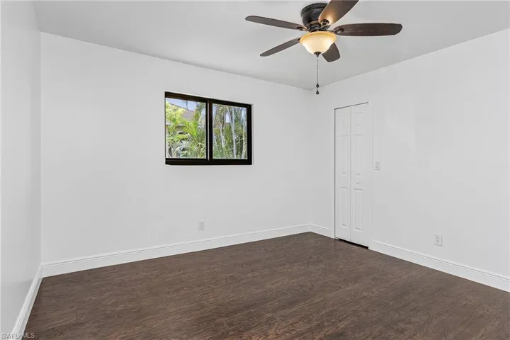 Unfurnished room with dark hardwood / wood-style floors and ceiling fan