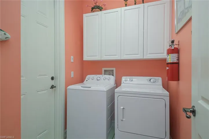 Laundry area with washing machine and clothes dryer, washer hookup, and cabinets