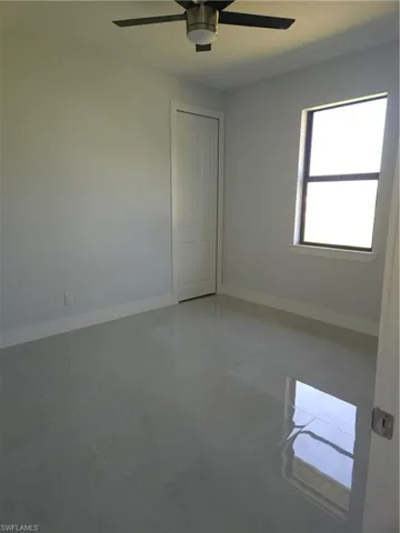 Tiled spare room with ceiling fan