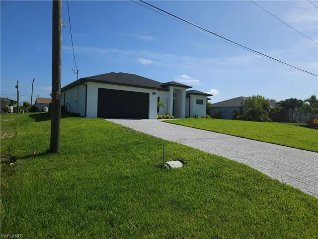View of front facade with a garage and a front lawn