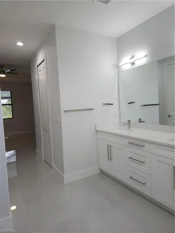 Bathroom featuring tile patterned floors, vanity, and ceiling fan