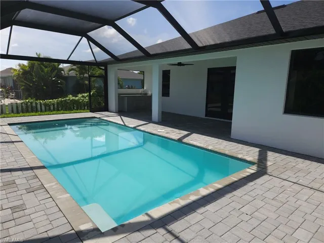 View of pool with ceiling fan, a patio area, and a lanai