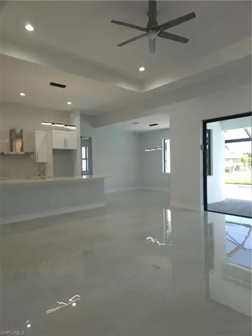 Unfurnished room featuring light tile patterned floors, a wealth of natural light, and ceiling fan
