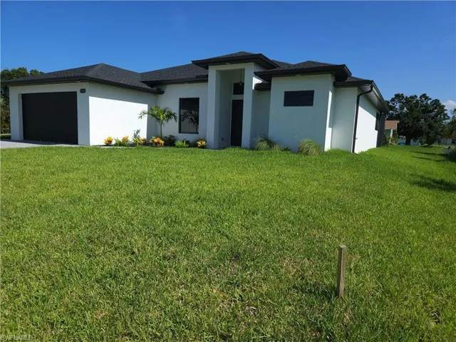 View of front of house featuring a garage and a front lawn